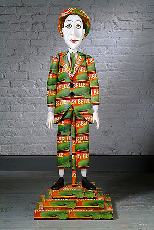 The Cucumber Salesman puppet is dressed in a suit of old cucumber packing labels